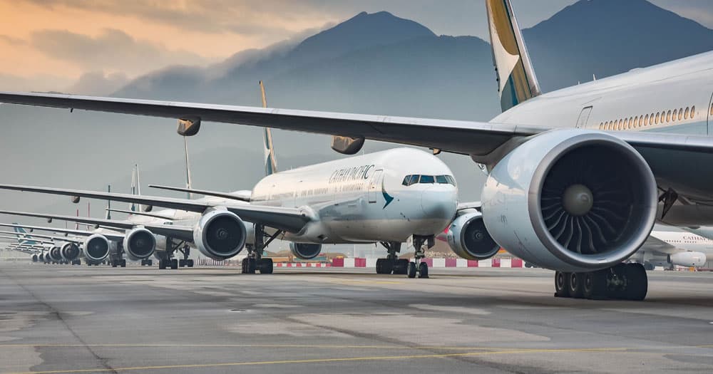 Fixed wing aircraft on runway with mountains in the background