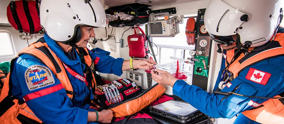 Emergency medical services crew onboard helicopter with medical equipment