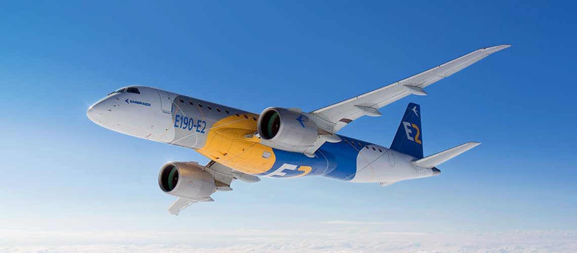 Embraer E2 jet flying against blue sky