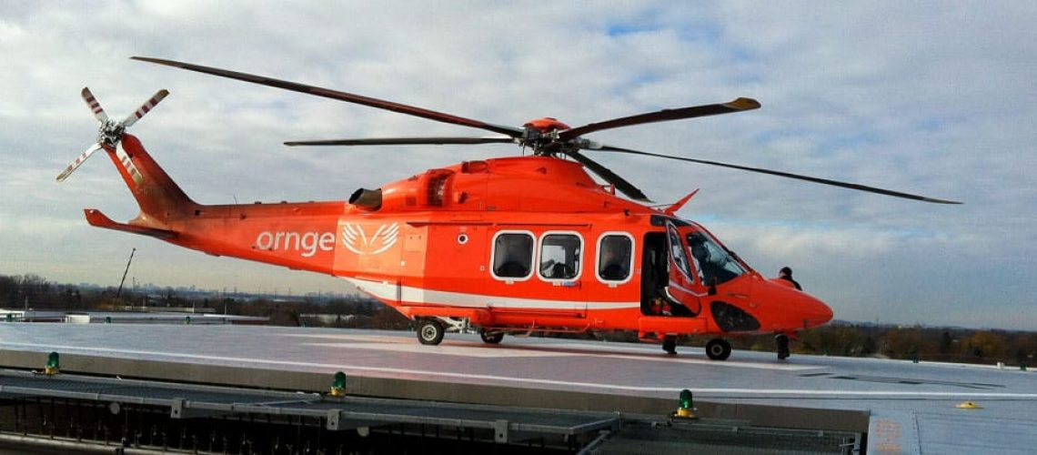 orgne EMS helicopter parked on helipad